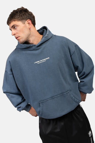 Blauw sweatshirt met kap van KAOTIKO, met tekstprint en buidelzak, gedragen met een zwarte broek.

