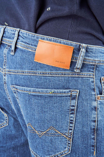 Middenblauwe straight jeans denim van MAC Jeans, met een bruin leren label en decoratieve stiksels op de achterzak.
