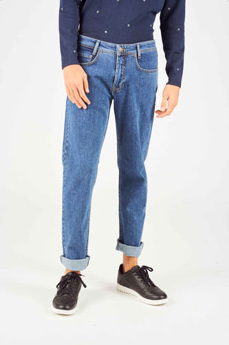 Jeans straight mid blue denim van MAC, met opgerolde broekspijpen en gecombineerd met zwarte schoenen en een donkerblauw shirt met print.

