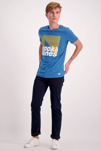 Jean bleu marine droit de MAC, avec des poches pliées et des baskets blanches.