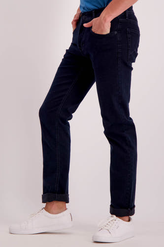 Jean denim bleu marine droit de MAC, avec des poches rabattues et des baskets blanches.