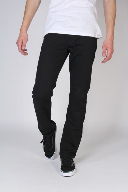 Zwarte straight jeans denim van MAC, gedragen met een wit T-shirt en zwarte sneakers.
