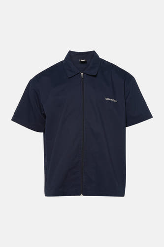 Blauw overhemd met korte mouwen van KAOTIKO, met een ritssluiting en de tekst "MORNING CALLS" op de borst.
