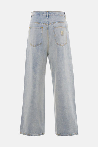 Jean en denim bleu clair large de KAOTIKO, avec poches arrière et une étiquette sur la poche droite.