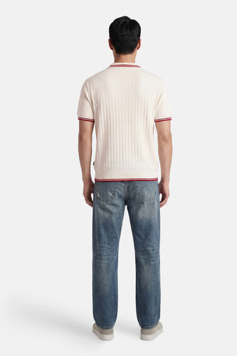 Witte polo van KAOTIKO, met korte mouwen en rode details aan de kraag en mouwen.