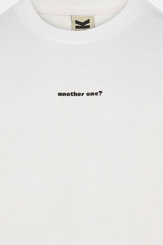 Wit T-shirt van KAOTIKO met de tekst "another one?" in het zwart.