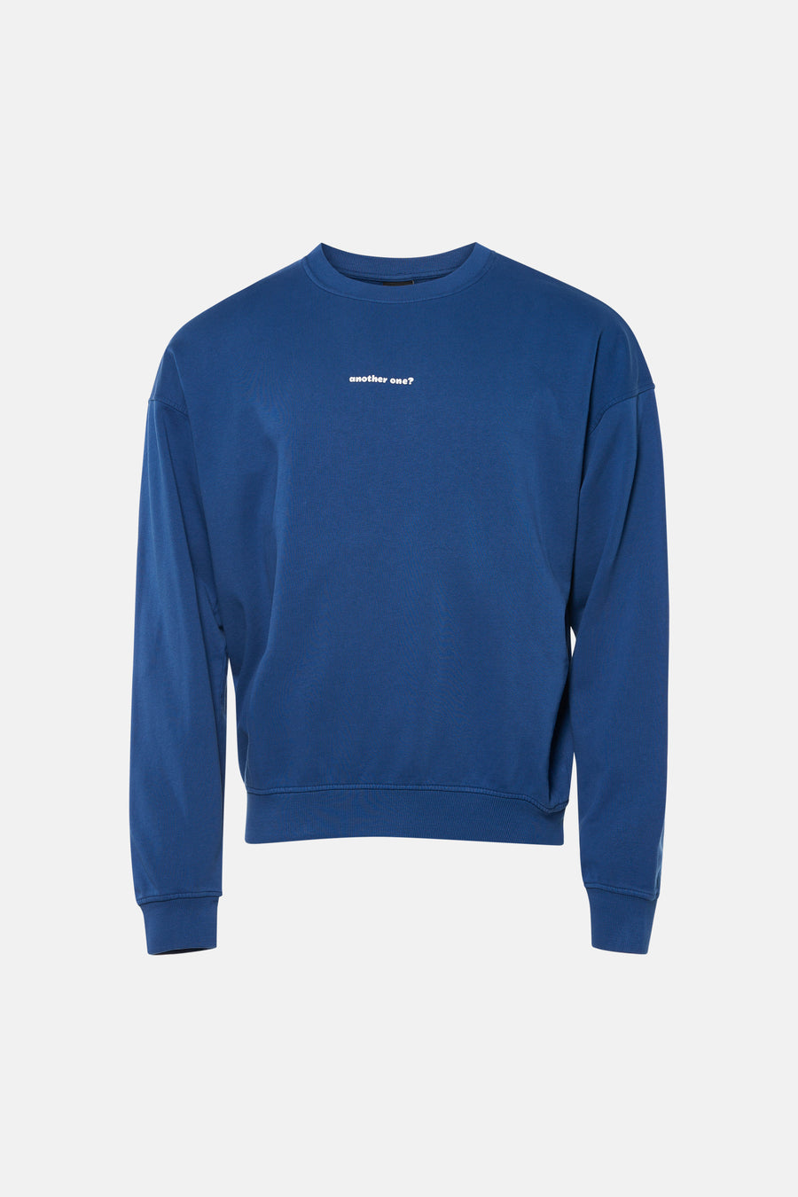 Pull bleu de KAOTIKO, avec un texte blanc sur la poitrine, combiné avec un jean foncé et des baskets blanches.
