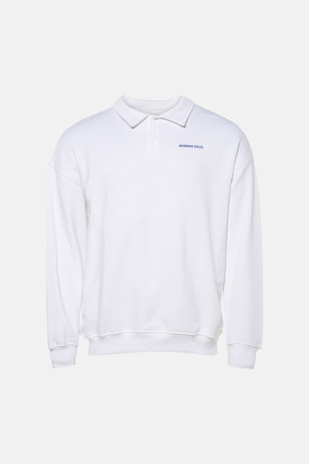 Witte sweater van KAOTIKO, met een polokraag en blauwe tekst op de borst.