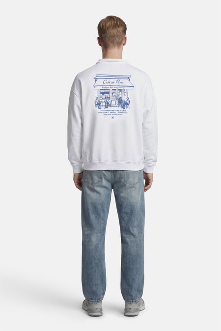 Witte sweater van KAOTIKO, met blauwe Café de Paris print op de rug.