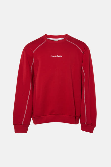 Rode sweater van KAOTIKO, met lange mouwen en witte stiksels langs de randen.