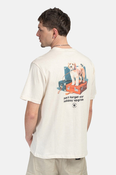 T-shirt écru de KAOTIKO avec un imprimé de chien sur une pile de valises au dos.