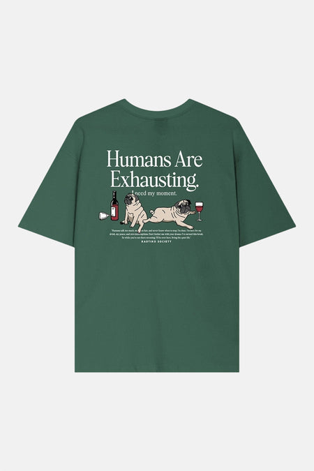 T-shirt vert de KAOTIKO avec un imprimé humoristique de carlins et le texte "Humans Are Exhausting".