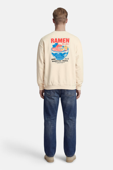 Ecru sweater van KAOTIKO, met een grafische print van een kom ramen op de rug.

