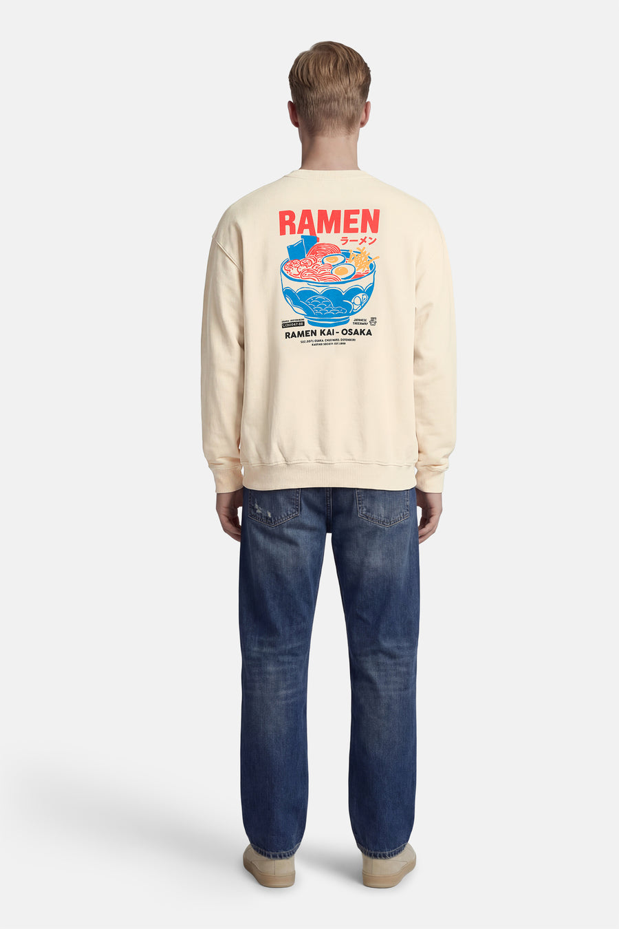 Pull écru de KAOTIKO, avec un imprimé graphique d'un bol de ramen dans le dos.