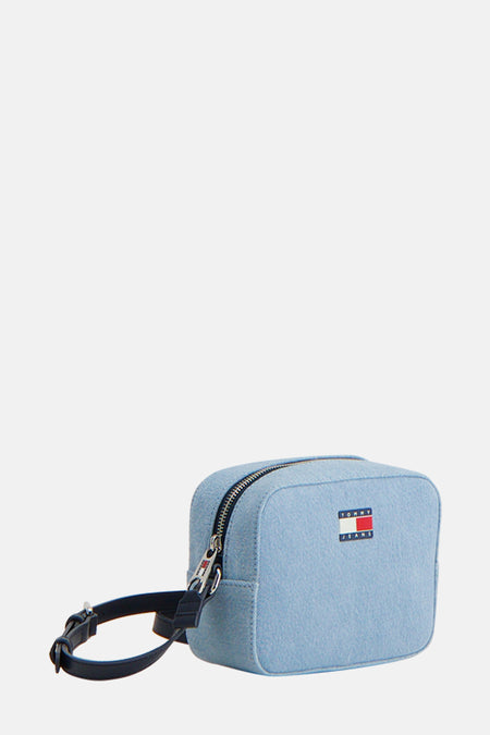 Lichtblauwe denim schoudertas van TOMMY JEANS, met zilverkleurige ritssluiting en zwarte band.