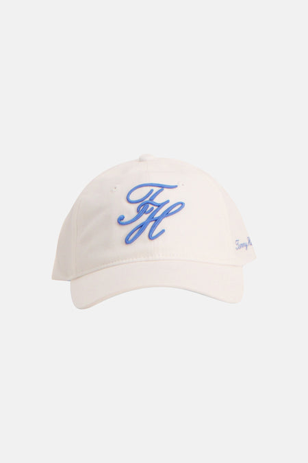 Witte pet van TOMMY JEANS met een gestileerd blauw TH-logo en kleine blauwe letters op de zijkant.