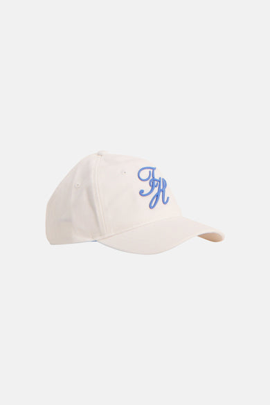 Witte pet van TOMMY JEANS met een geborduurd blauw TH-monogram, vanuit zijprofiel.