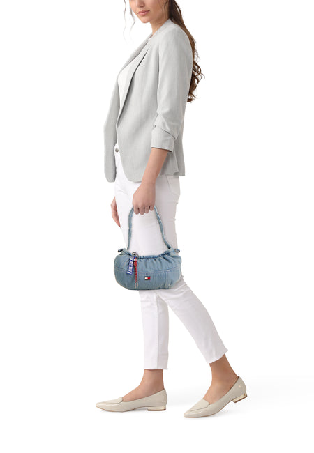 Blauwe denim schoudertas van TOMMY JEANS, met ritsdetails en logo, gedragen door model in zijaanzicht