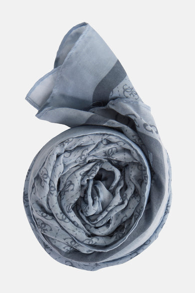 Blauwe zomersjaal van Guess met subtiele, donkerdere logoprint en gerolde presentatie.
