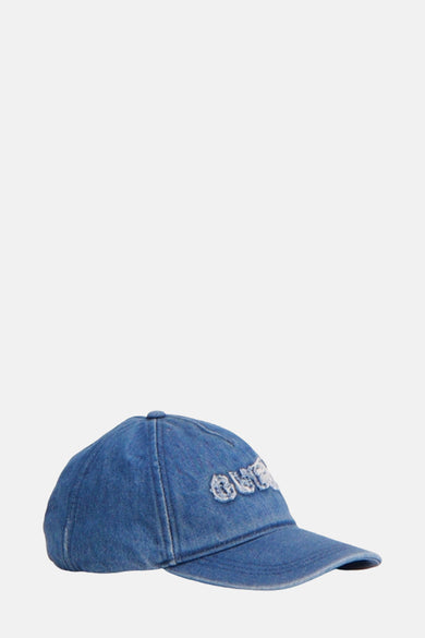 Blauw denim pet van Guess, met geborduurd logo op de voorkant, in zijaanzicht.
