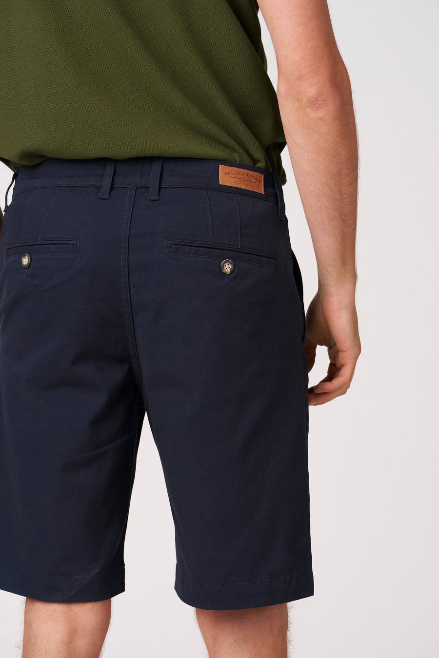 Blauwe bermuda van Bruce & Butler, met achterzakken en een bruin lederen label aan de tailleband.
