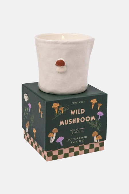 Groene kaars in witte keramische houder met paddenstoeldecoratie, van PADDY WAX, op donkergroene doos met paddenstoelprint