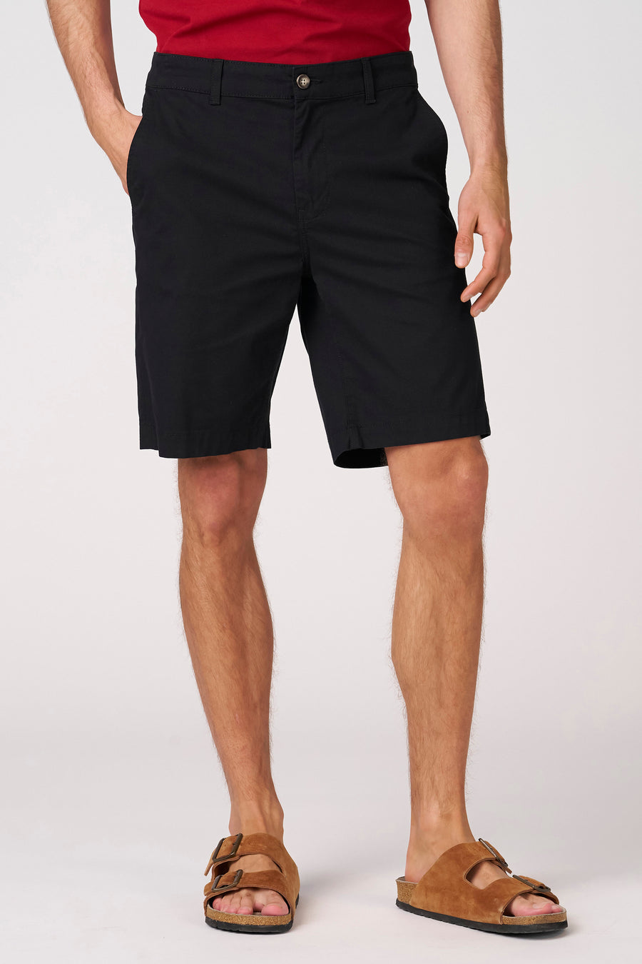 Zwarte bermuda short van Bruce & Butler, gedragen met bruine sandalen en een rood shirt.