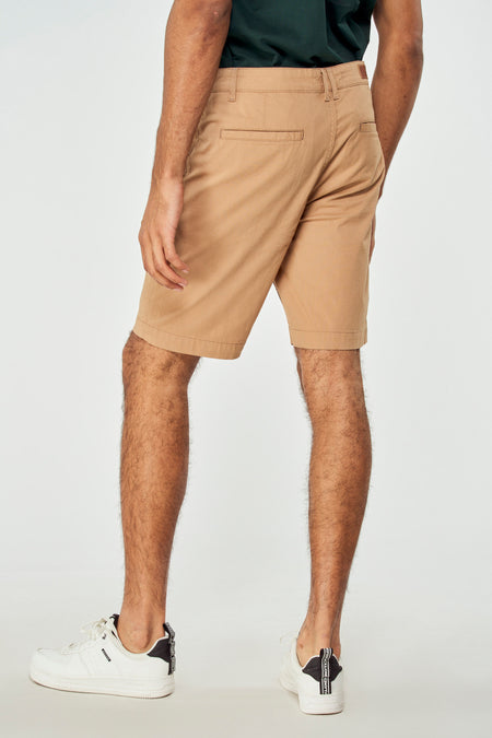 Bruine short van Bruce & Butler, gezien van achteren, gecombineerd met een donkergroen shirt en witte sneakers.

