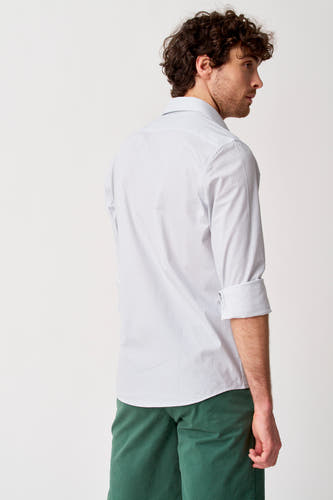 Wit hemd met lange mouwen van Bruce & Butler, zijaanzicht, met stippenpatroon, opgerolde mouwen en groene korte broek.