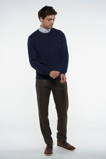 Blauwe trui met ronde hals van Bruce & Butler, gedragen over een overhemd met print en bruine corduroy broek.