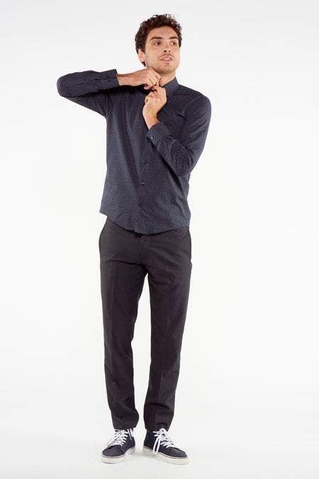 Pantalon de costume bleu foncé de Bruce & Butler avec motif subtilement tissé, combiné avec une chemise et des baskets.