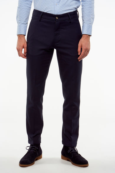 Blauwe kostuumbroek van Bruce & Butler, met een subtiele textuur en gecombineerd met een lichtblauw overhemd en donkerblauwe schoenen.