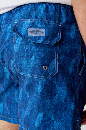 Blauwe zwemshort van Bruce & Butler, met bladmotief en zak met drukknoop detail.