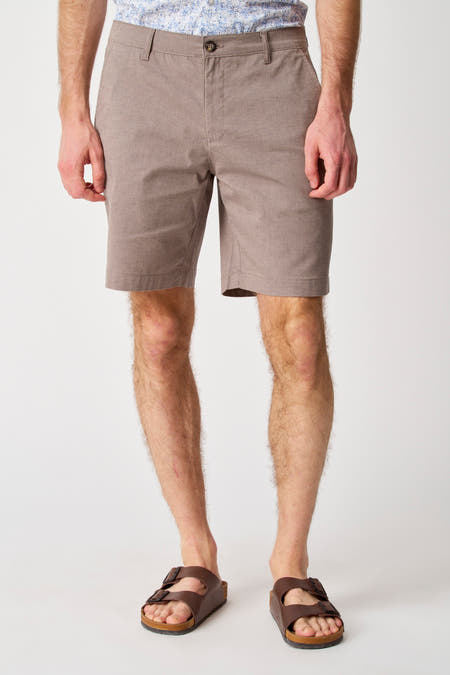 Beige short van Bruce & Butler, met subtiele textuur en een klassieke pasvorm, gedragen met sandalen.
