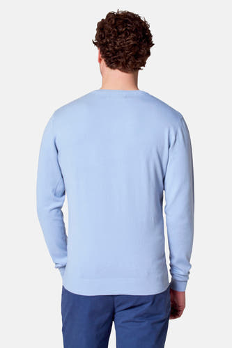 Lichtblauwe V-hals trui van Bruce & Butler, achterkant gezien, met blauwe broek.
