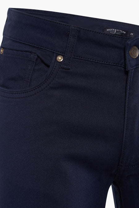Blauwe broek van Bruce & Butler, close-up van de tailleband met knoop en zak.

