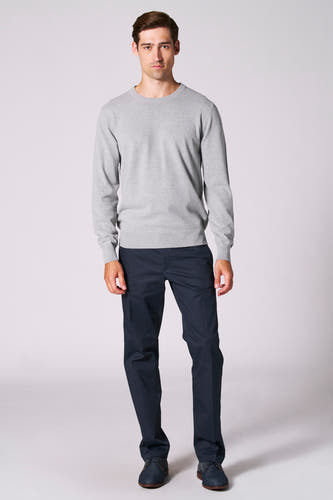 Sweater gris avec col rond de Bruce & Butler, porté avec un pantalon bleu marine et des chaussures bleues.