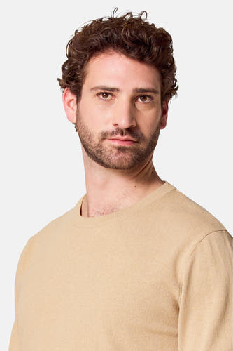 Gilet beige à col rond de Bruce & Butler, portrait rapproché d'un homme portant l'article.