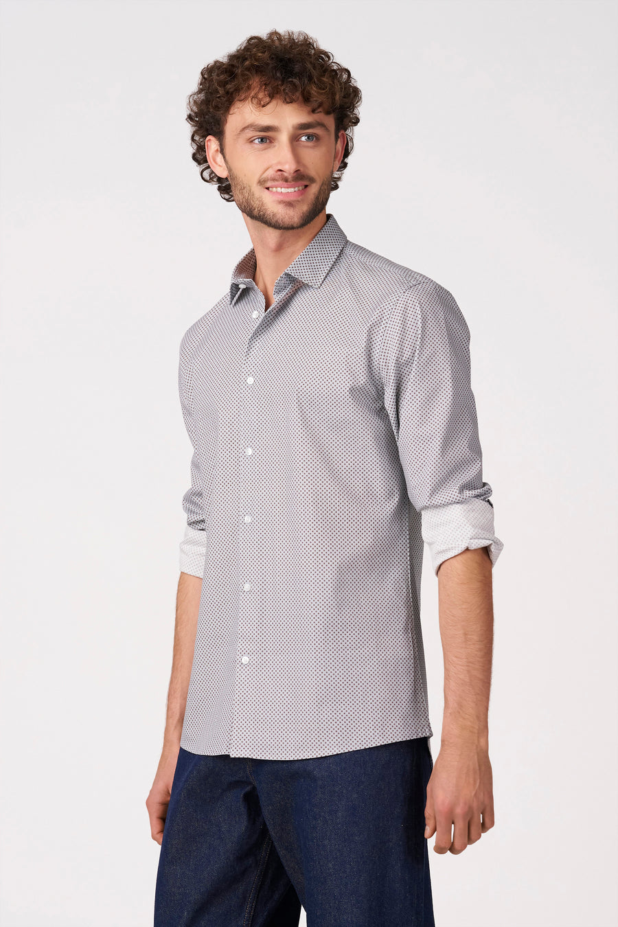 Grijs overhemd met lange mouwen van Bruce & Butler, met subtiel patroon en opgerolde mouwen, gedragen met donkere jeans.
