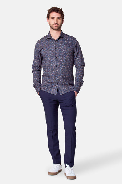 Chemise noire à manches longues de Bruce & Butler, avec un motif floral subtil, associée à des pantalons bleu marine et des baskets blanches.