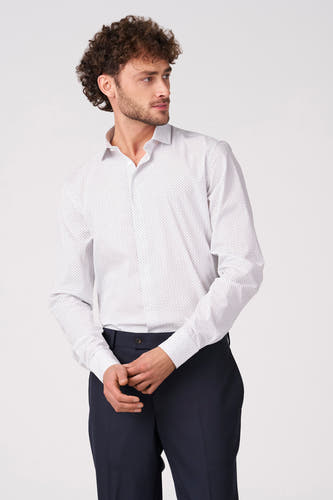 Wit overhemd (lange mouwen) van Bruce & Butler, met subtiele stippen en gedragen met een donkerblauwe pantalon.

