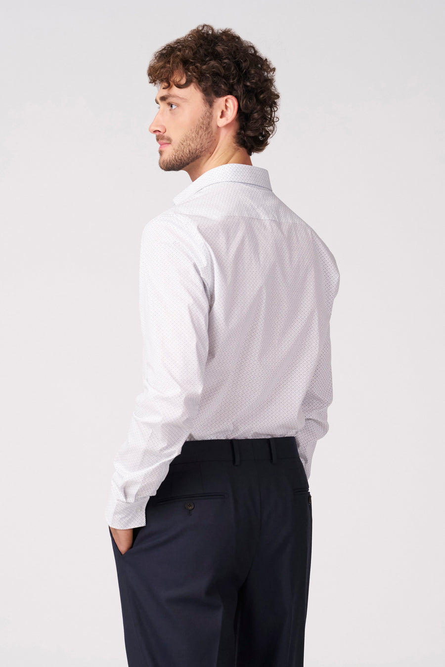 Wit overhemd met lange mouwen van Bruce & Butler, met een subtiel stippenpatroon, gecombineerd met een donkere pantalon.