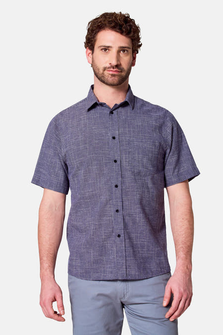 Chemise bleue à manches courtes de Bruce & Butler, avec un fin motif à carreaux, portée avec un pantalon bleu.