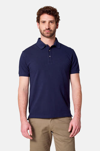 Polo bleu marine à manches courtes de Bruce & Butler, porté avec un pantalon beige.