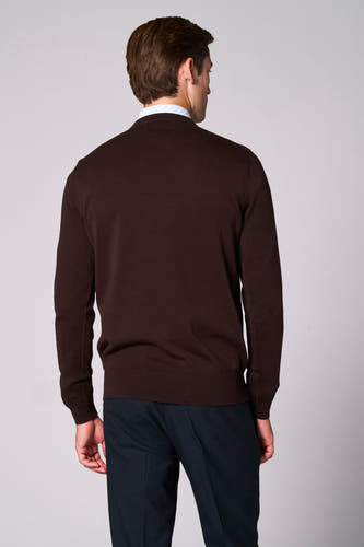 Pull brun à col V de Bruce & Butler, vu de l'arrière, avec un chemisier en dessous et des pantalons bleu marine.