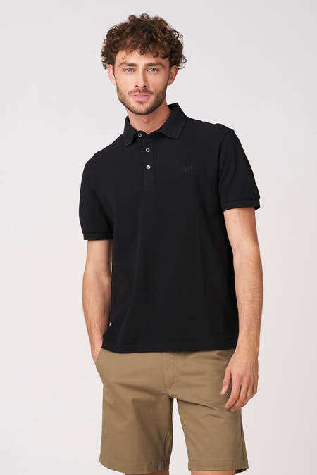 Polo noire à manches courtes de Bruce & Butler, vue de dos, combinée avec un pantalon kaki.
