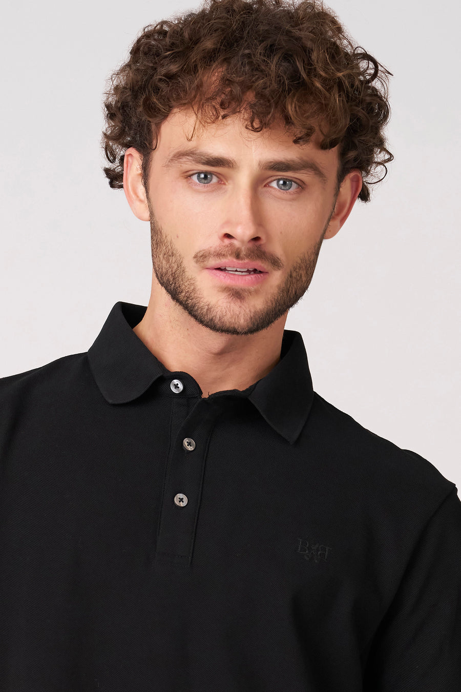 Polo noire à manches courtes de Bruce & Butler, avec un col classique et une fermeture à boutons.