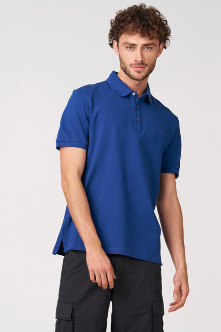 Polo bleu à manches courtes de Bruce & Butler, vue de dos, portée avec un pantalon noir.