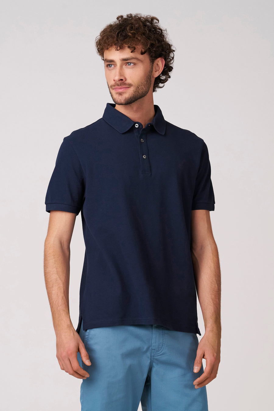 Polo bleu à manches courtes de Bruce & Butler, porté avec un pantalon bleu clair.