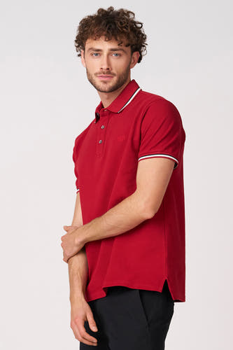 Polo rouge à manches courtes de Bruce & Butler, avec passepoil blanc et noir au col et aux manches.